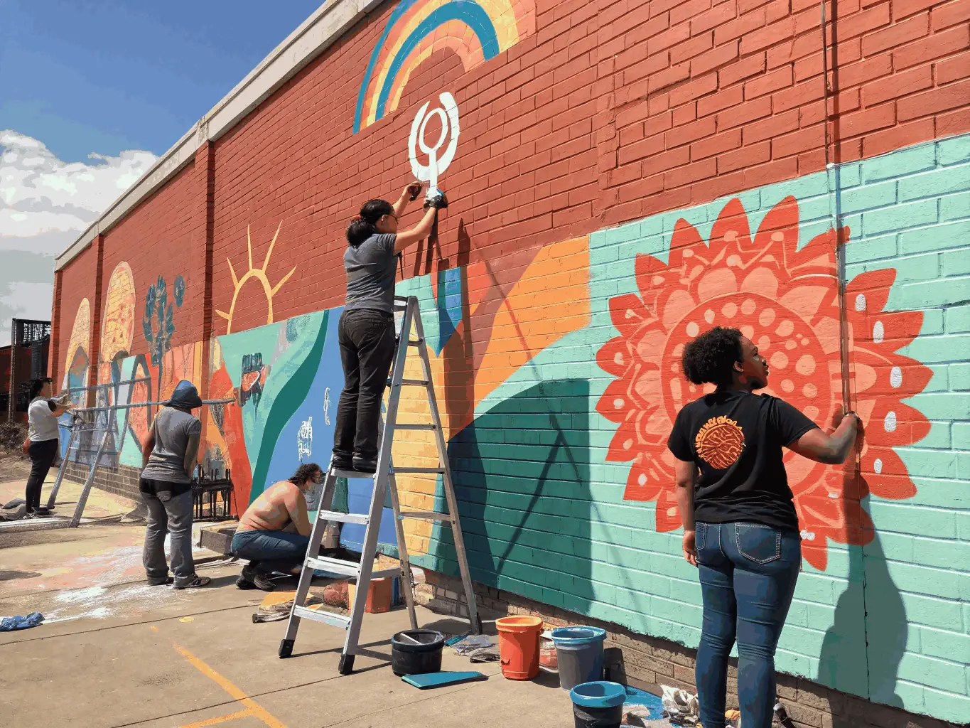 A vibrant image showing a diverse group of artists collaborating on a community mural project, reflecting the collaborative spirit and community enrichment fostered by ASSOCIATION LE CLAVIER.
